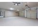 Spacious three-car garage with epoxy floors, lots of storage cabinets, and two automatic doors at 19608 N Regents Park Dr, Surprise, AZ 85387