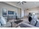 Open living room with modern furniture, sleek entertainment center and light hardwood floors at 19608 N Regents Park Dr, Surprise, AZ 85387