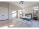 Sunlit main bedroom showcasing modern furnishings, large windows, and neutral tones at 19608 N Regents Park Dr, Surprise, AZ 85387