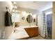 Well-lit bathroom featuring double sinks, granite countertops, and shower with gray tile surround at 20609 N 4Th Ave, Phoenix, AZ 85027