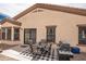 Outdoor dining area with a patio table, chairs, and a barbecue grill set against a beige stucco house at 2101 S Meridian Rd # 176, Apache Junction, AZ 85120