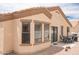 Outdoor patio area with a dining set and a barbecue grill, set against a beige stucco exterior at 2101 S Meridian Rd # 176, Apache Junction, AZ 85120