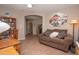 Comfortable living room featuring a brown couch, a wooden desk, and an art piece at 2101 S Meridian Rd # 176, Apache Junction, AZ 85120