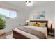 Bright bedroom with a wooden bed frame, plush rug, and a sunny window view at 2145 W Cholla St, Phoenix, AZ 85029