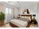 Comfortable bedroom with a wood bed frame, bedside lamps, and natural light from the window at 2145 W Cholla St, Phoenix, AZ 85029