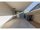 View of the shaded carport with access door to the residence, and trash receptacles at 2145 W Cholla St, Phoenix, AZ 85029