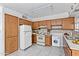 Functional kitchen featuring wood cabinetry, a white refrigerator, and essential appliances, including a washer for added convenience at 2145 W Cholla St, Phoenix, AZ 85029