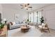 Bright living room featuring a neutral-toned sofa, modern decor, ample natural light, and a ceiling fan for added comfort at 2145 W Cholla St, Phoenix, AZ 85029