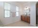 Bright bathroom featuring double windows, neutral tile flooring, granite vanity, and expansive mirror at 27380 N 128Th Ln, Peoria, AZ 85383