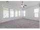 Bright and airy carpeted bedroom with large windows and a ceiling fan at 27380 N 128Th Ln, Peoria, AZ 85383