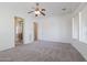 Bedroom with large windows, closet access, ceiling fan, and carpet flooring at 27380 N 128Th Ln, Peoria, AZ 85383