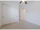 Well-lit carpeted bedroom with closet and a view into an adjacent room at 27380 N 128Th Ln, Peoria, AZ 85383