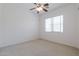 Light-filled bedroom showcasing a carpeted floor, ceiling fan, and window at 27380 N 128Th Ln, Peoria, AZ 85383