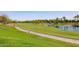 Scenic view of a lush green golf course with a pond and palm trees in the background at 27380 N 128Th Ln, Peoria, AZ 85383