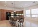 Open concept kitchen with granite island with seating, and wood cabinets at 27380 N 128Th Ln, Peoria, AZ 85383