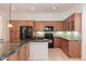 Bright kitchen offers granite counters, black appliances, and warm wood cabinetry at 27380 N 128Th Ln, Peoria, AZ 85383