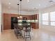 Spacious kitchen features a large granite island with seating, tile floor, and wood cabinets at 27380 N 128Th Ln, Peoria, AZ 85383