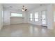 Open-plan living room with large windows, neutral walls, and tile flooring at 27380 N 128Th Ln, Peoria, AZ 85383
