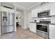Modern kitchen with stainless steel refrigerator, white cabinets, and views into the dining area at 3029 E Patrick St, Gilbert, AZ 85295