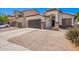 A charming single-story home featuring a brown garage door and decorative stone accents at 3528 W Paseo Way, Laveen, AZ 85339