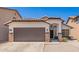 Charming single-story home featuring a brown garage door and decorative stone accents at 3528 W Paseo Way, Laveen, AZ 85339