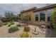 Backyard featuring gravel landscaping, patio area with seating, and lush plants at 36042 N Desert Tea Dr, Queen Creek, AZ 85140