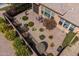 Neat backyard with patio area surrounded by lush plants, manicured bushes, gravel, and floral landscaping at 36042 N Desert Tea Dr, Queen Creek, AZ 85140