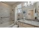 Well-lit bathroom featuring marble tile surround, granite vanity top, and shower-tub combination at 36042 N Desert Tea Dr, Queen Creek, AZ 85140
