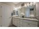 Bathroom featuring double sinks, granite countertops, and a large mirror with stylish lighting fixtures at 36042 N Desert Tea Dr, Queen Creek, AZ 85140