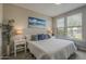 Serene bedroom with a large bed, soft lighting, and windows providing a view of the outdoors at 36042 N Desert Tea Dr, Queen Creek, AZ 85140