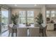 Bright dining room features a wooden table, upholstered chairs, and a view to the outdoors at 36042 N Desert Tea Dr, Queen Creek, AZ 85140
