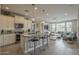 Spacious kitchen featuring a granite island, stainless steel appliances, and views of the living area at 36042 N Desert Tea Dr, Queen Creek, AZ 85140