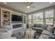 Inviting living room featuring a cozy fireplace, custom built-ins, and large windows offering ample natural light at 36042 N Desert Tea Dr, Queen Creek, AZ 85140