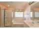 Clean bathroom with walk-in shower and bath with natural light at 3665 E Thames Way, San Tan Valley, AZ 85140