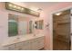Well-lit bathroom with dual sinks, mirror, and a walk-in closet at 3665 E Thames Way, San Tan Valley, AZ 85140