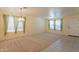 Bright living room with a ceiling fan, neutral carpet and trim, and many windows at 3665 E Thames Way, San Tan Valley, AZ 85140