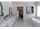 Elegant bathroom featuring marble floors, dual sinks, and a modern soaking tub at 3813 N 37Th St, Phoenix, AZ 85018