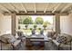 Covered patio with cushioned seating and a fire pit overlooking the beautifully landscaped backyard at 3813 N 37Th St, Phoenix, AZ 85018
