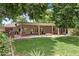 Expansive backyard featuring a covered patio, outdoor kitchen, brick fire pit, and lush lawn, perfect for entertaining at 3817 E Highland Ave, Phoenix, AZ 85018
