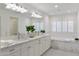 Bathroom featuring double sinks, marble countertops, and stylish black and white tile flooring at 3817 E Highland Ave, Phoenix, AZ 85018