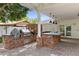 Covered outdoor kitchen with brick counters, grill, and sink for cooking and entertaining al fresco at 3817 E Highland Ave, Phoenix, AZ 85018