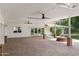 Covered outdoor patio with ceiling fans, recessed lighting, and a brick fire pit for year-round enjoyment at 3817 E Highland Ave, Phoenix, AZ 85018