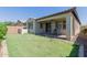 Backyard featuring a covered patio, green lawn, and privacy wall, ideal for outdoor living and entertaining at 3892 E Harrison St, Gilbert, AZ 85295