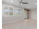 Bright, neutral living area with tile flooring, dual windows with white shutters, and sliding doors to the backyard at 3892 E Harrison St, Gilbert, AZ 85295