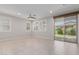 Bright and airy living room features tile flooring, a ceiling fan, neutral paint, and sliding glass doors at 3892 E Harrison St, Gilbert, AZ 85295