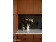 Chic kitchen boasting warm wood cabinetry, a black tiled backsplash, and white countertops at 4032 N 45Th Pl, Phoenix, AZ 85018