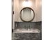 Half-bathroom boasts marble countertop, wood-trimmed round mirror, and a sleek design at 4132 N 42Nd St, Phoenix, AZ 85018