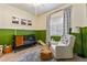 Bright Bedroom with green wainscoting, a crib, chair, and an area rug at 4132 N 42Nd St, Phoenix, AZ 85018