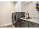 Functional laundry room featuring a sink, gray cabinets, and stacked washer and dryer at 4132 N 42Nd St, Phoenix, AZ 85018