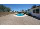 Backyard with a rectangular pool, covered patio, brick fence, and gravel landscaping at 4234 E Winnetka Dr, Phoenix, AZ 85044